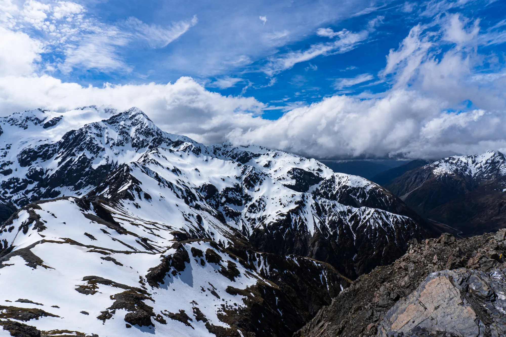 Snow-covered ridgelines of the Southern Alps under drifting cloud, seen from Avalanche Peak, Arthur's Pass